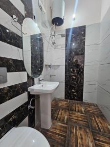 W łazience znajduje się umywalka, toaleta i lustro. w obiekcie Jairaj Ecostay w mieście Shāmli