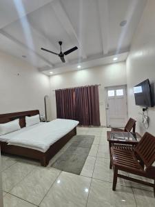 1 dormitorio con 1 cama y TV de pantalla plana en Jairaj Ecostay, en Shāmli