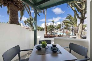 stół i krzesła z widokiem na ośrodek w obiekcie Bungalow La Roca w Costa Teguise