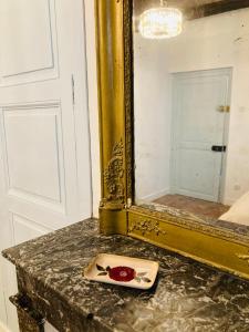 a plate with a rose on a counter in front of a mirror at AU LION D OR in Auxerre