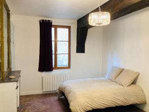 a bedroom with a bed and a window and a chandelier at AU LION D OR in Auxerre