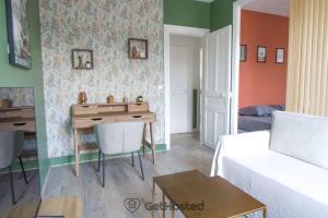 ein Wohnzimmer mit einem weißen Sofa und einem Schreibtisch in der Unterkunft Charming Flat at the gates of Paris - GetHosted in Asnières-sur-Seine