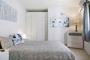 コスタ・テギセにあるBungalow La Rocaの白いベッドルーム(ベッド1台、ドレッサー付)