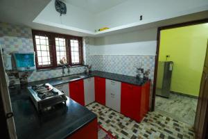 a kitchen with red and white cabinets and a stove at Parkhil Homes in Cochin