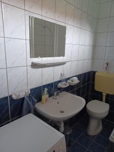 a bathroom with a sink and a toilet and a mirror at Levendula Apartman Nyíregyháza in Nyíregyháza