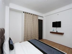 sypialnia z łóżkiem i telewizorem z płaskim ekranem w obiekcie Summer King w mieście Nainital