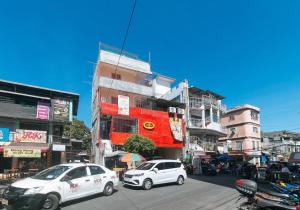 two white cars parked on a city street with buildings at RedDoorz @ Western Bicutan Transients Inn in Manila