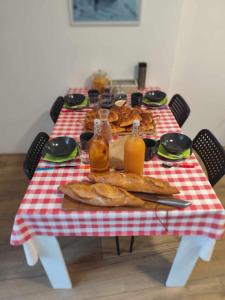 una mesa con un mantel a cuadros rojo y blanco en HOULALA Gîte & Chambres d'hôtes, en Pont-Évêque