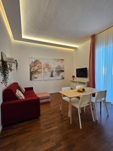a living room with a table and a red couch at Pangea - Asia in Trani