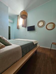 een slaapkamer met een bed en twee spiegels aan de muur bij Pangea in Trani