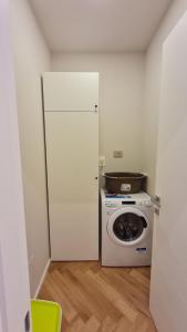 Il comprend une cuisine équipée d'un réfrigérateur blanc et d'un lave-linge. dans l'établissement Apartament Bologna-Stadio 2, à Bologne