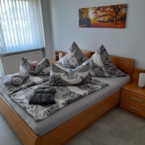 a bed with a bunch of pillows on it at Bichlhof Bärfra Ferienwohnung Hunsrück in Morbach