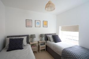 a bedroom with two beds and a window at Surf Cottage in Cromer