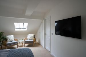 a room with two chairs and a flat screen tv at Surf Cottage in Cromer