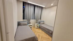 Cette petite chambre comprend 2 lits et un miroir. dans l'établissement Apartament Bologna-Stadio 2, à Bologne