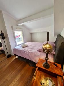 1 dormitorio con 1 cama y 1 mesa con lámpara en Colourful loft in Marseille, en Marsella