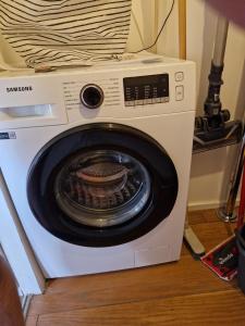 a white washing machine sitting on a floor at Prado Spacious and Sunny Loft in Marseille in Marseille
