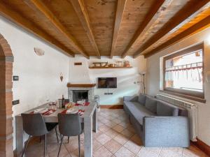 a living room with a table and a couch at Villetta a schiera, giardino privato e box doppio in San Pietro