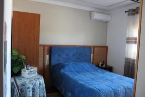 a bedroom with a blue bed and a table at Quinta de São Marcos in Fundão