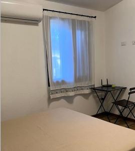 a bedroom with a bed and a window with a table at Bidd’e Majori in San Priamo
