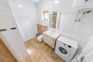 a white bathroom with a washing machine in it at Lider House Energy in Smolice