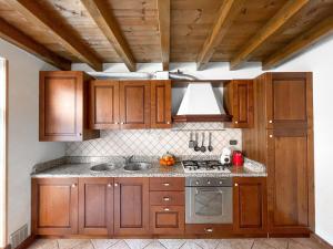 eine Küche mit Holzschränken und einem Herd in der Unterkunft Villetta a schiera, giardino privato e box doppio in San Pietro