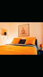 a bed with orange pillows and a picture on the wall at Villa accès port plage à pied sanary sur mer in Sanary-sur-Mer