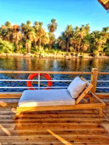 a bed sitting on a dock next to a body of water at Dahabiya Nile Sailing-Safiya-Aswan to Luxor-every Friday-4 days-3 nights in Aswan