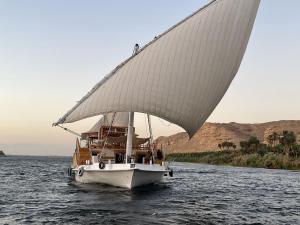 亞斯文的住宿－Dahabiya Nile Sailing-Safiya-Aswan to Luxor-every Friday-4 days-3 nights，一艘在水中装有大帆的船