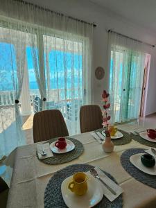 een eettafel met borden en bekers erop bij Seaside Jon Saranda in Sarandë +21 foto's