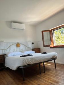 1 dormitorio con cama con espejo y ventana en Il Cardo da Pasquarè, en Foligno