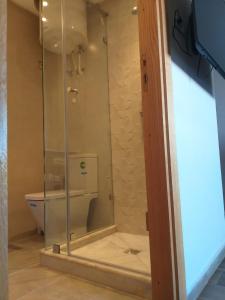 a glass shower in a bathroom with a toilet at Sidi Rahal Blue Beach Appartement Pieds Dans L'eau in Sidi Rahal