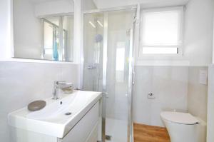 a white bathroom with a sink and a shower at Bellavista in Caorle