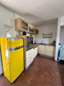 eine Küche mit einem gelben Kühlschrank und weißen Schränken in der Unterkunft Il Cardo da Pasquarè in Foligno