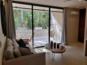 a living room with a couch and a table at Little Oasis with private pool in the jungle in Chemuyil