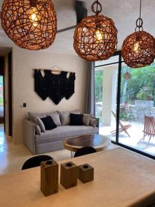 a living room with a couch and a table at Little Oasis with private pool in the jungle in Chemuyil