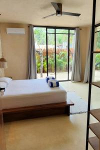 a bedroom with a bed and a large window at Little Oasis with private pool in the jungle in Chemuyil
