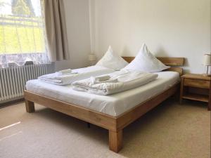 a bed with white sheets and pillows on it at Schwarzwaldhaus Sonnenstraße, Oberried-Hofsgrund, Dreisamtal in Oberried