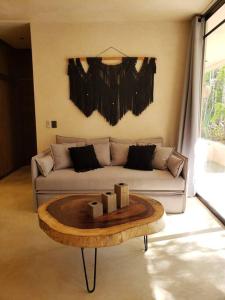 a living room with a couch and a coffee table at Little Oasis with private pool in the jungle in Chemuyil