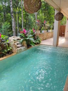 a swimming pool with blue water in a yard at Little Oasis with private pool in the jungle in Chemuyil