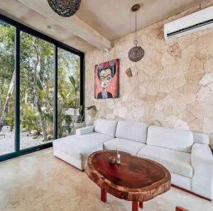 a living room with a white couch and a wooden coffee table at Little Oasis with private pool in the jungle in Chemuyil