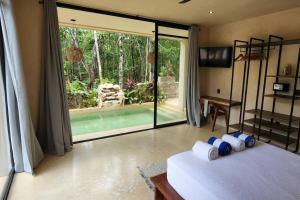 una camera con un letto e una grande porta scorrevole in vetro di Little Oasis with private pool in the jungle a Chemuyil Altre 34 foto