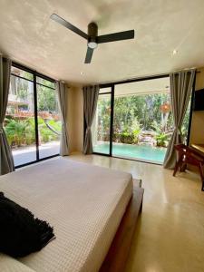 una camera con un grande letto e un ventilatore a soffitto di Little Oasis with private pool in the jungle a Chemuyil
