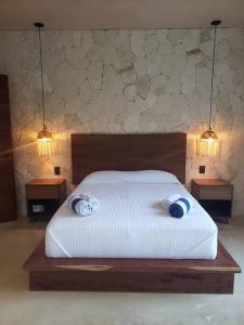 a bedroom with a bed with two pillows on it at Little Oasis with private pool in the jungle in Chemuyil