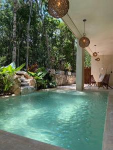 a swimming pool with blue water in a yard at Little Oasis with private pool in the jungle in Chemuyil