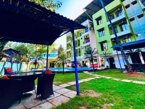 un parc avec une table et des chaises et un bâtiment dans l'établissement Hamilton Hotel & Resort Goa, à Goa