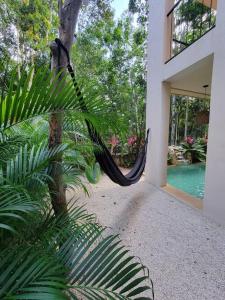 a hammock in the courtyard of a house at Little Oasis with private pool in the jungle in Chemuyil