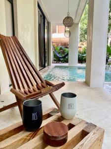 a wooden rocking chair sitting next to a pool at Little Oasis with private pool in the jungle in Chemuyil