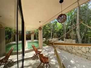 a patio with two chairs and a swimming pool at Little Oasis with private pool in the jungle in Chemuyil