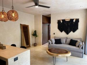 a living room with a couch and a table at Little Oasis with private pool in the jungle in Chemuyil
